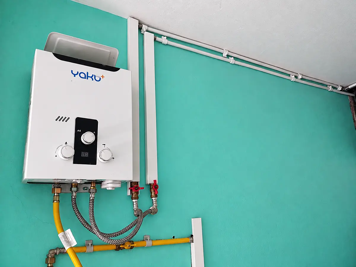 Terma a gas instalada con las tuberías blancas de agua caliente PEX-AL-PEX recorriendo la pared