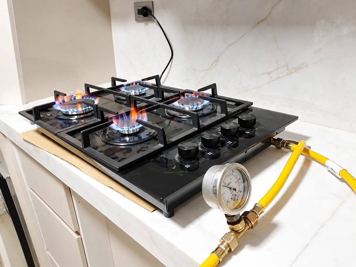 Cocina empotrada funcionando con gas natural y manómetro conectado para verificar la presión
