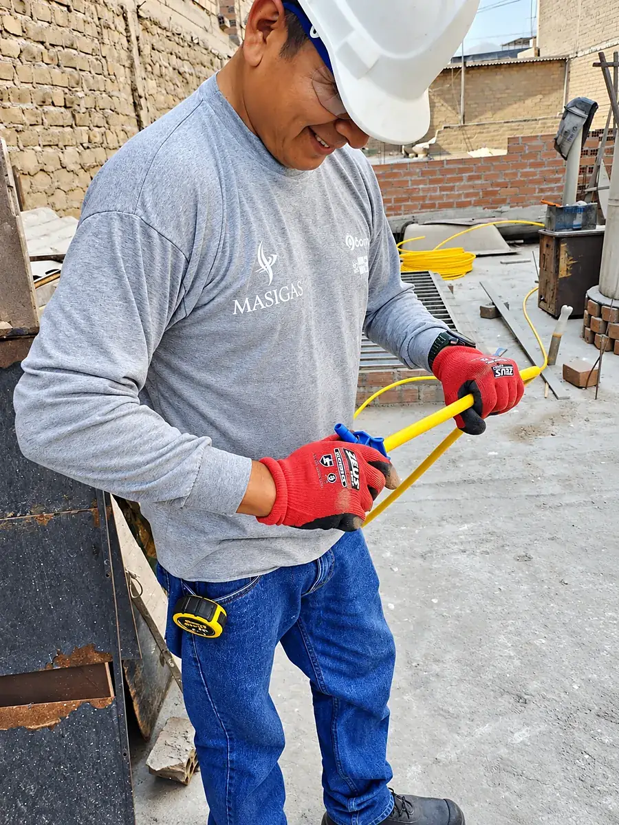 Técnico preparando la tubería amarilla para instalar el accesorio tee