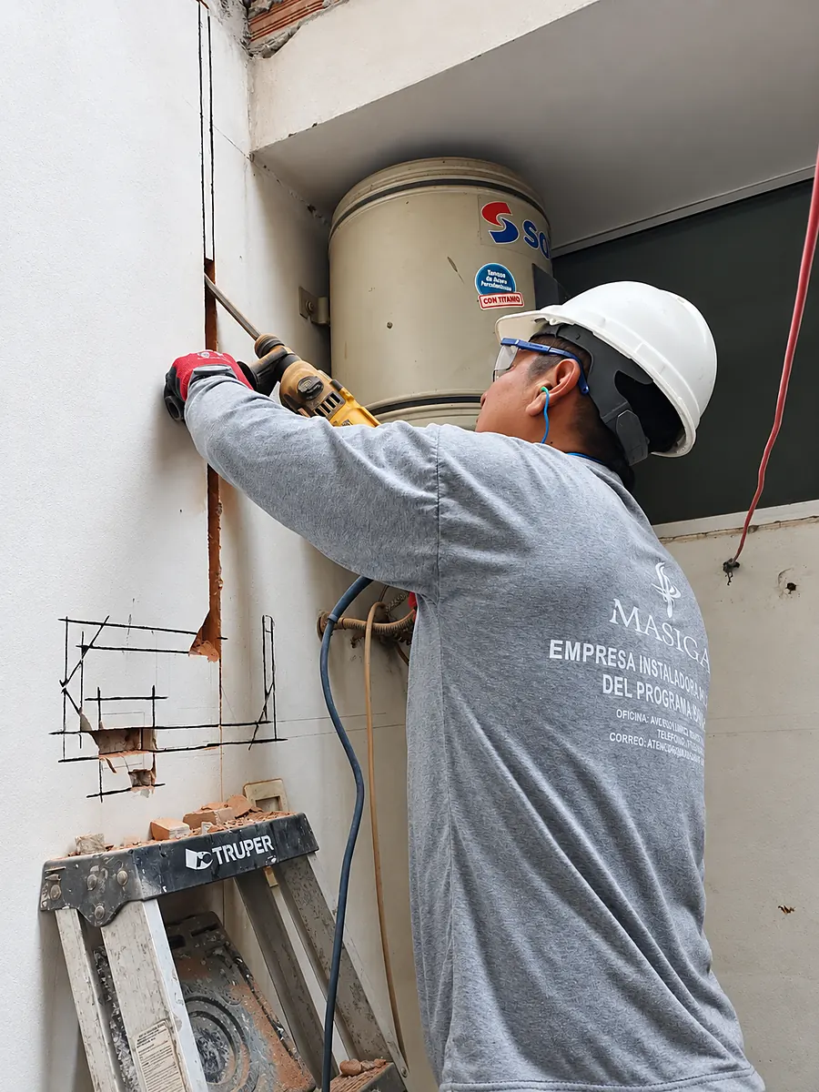 Técnico picando el muro para abrir la canaleta de la tubería