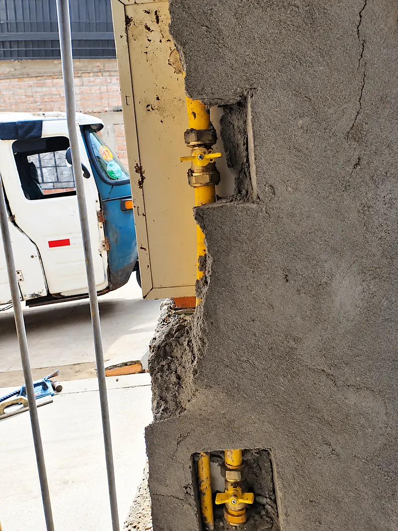 Lateral de la columna con las válvulas y tuberías de gas expuestas en huecos del muro