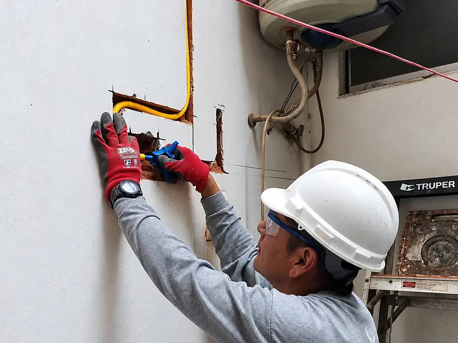 Técnico de MASIGAS colocando la tubería de gas dentro de la canaleta del muro